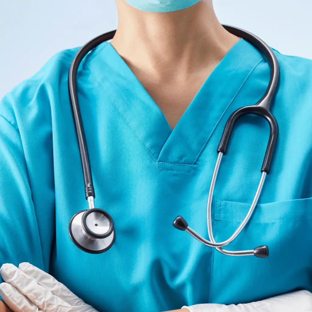 chest shot of doctor in blue with sthoscope around neck and surgical gloves